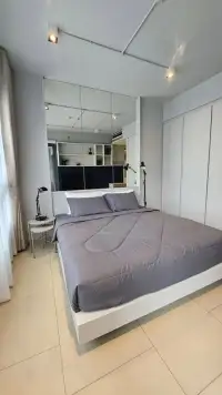 1 Bedroom Condo for Sale at Zire Wongamat bedroom with gray bed, mirrored wall, and built-in wardrobe