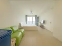 1 Bedroom Condo for Sale at Zire Wongamat bedroom with green sofa and sea-view window