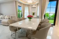 4 Bedroom House for Sale at Chokchai Garden Home 2, dining area with a white marble table, six chairs, and large windows.