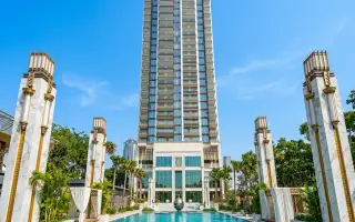Copacabana Beach Jomtien: Grand exterior view of the tall, modern condo building with decorative pillars and water feature.