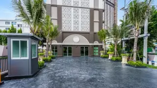 Arcadia Center Suite building entrance with ornate facade, palm trees, and security booth