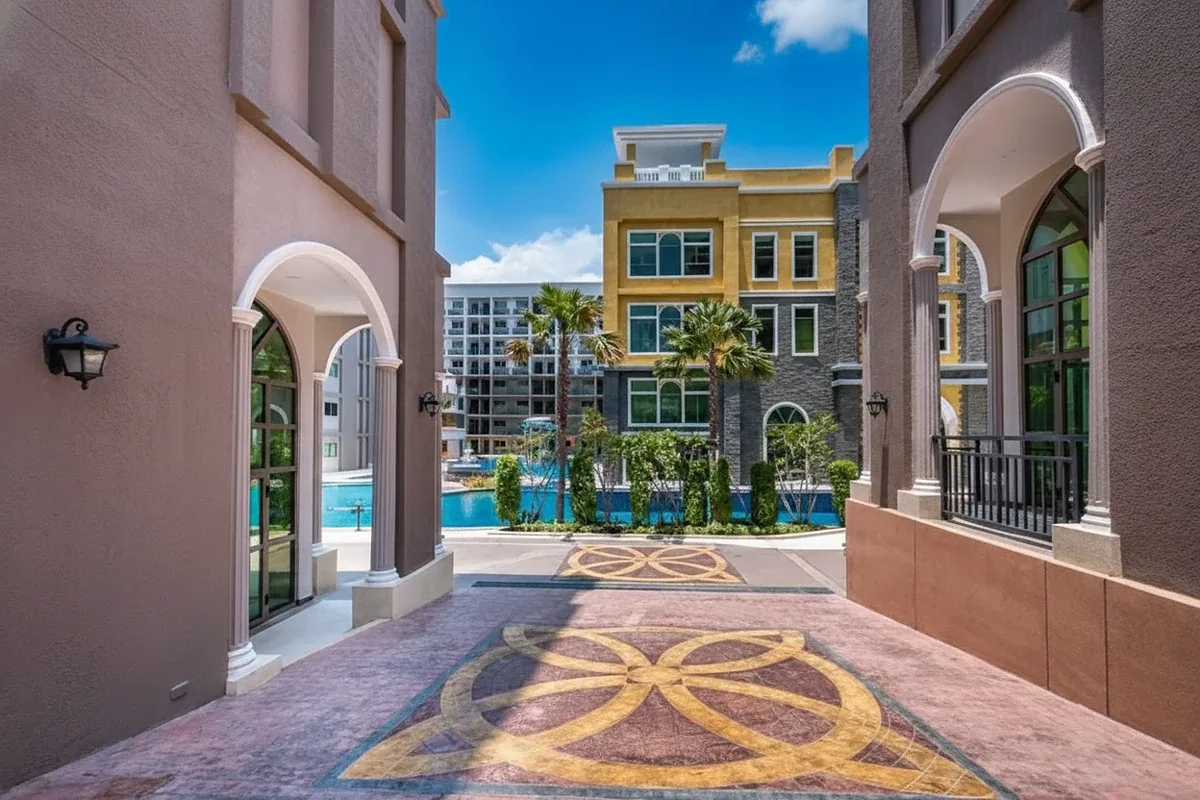 Arcadia Beach Continental: View through archways to the swimming pool area with palm trees and modern buildings.