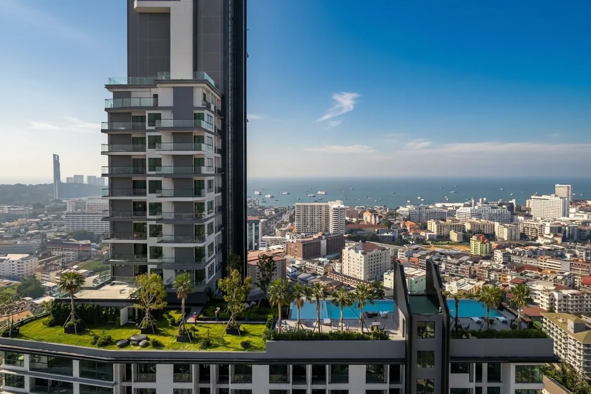 Arcadia Millennium Tower high-rise building with rooftop garden and pool, overlooking Pattaya city and the ocean.
