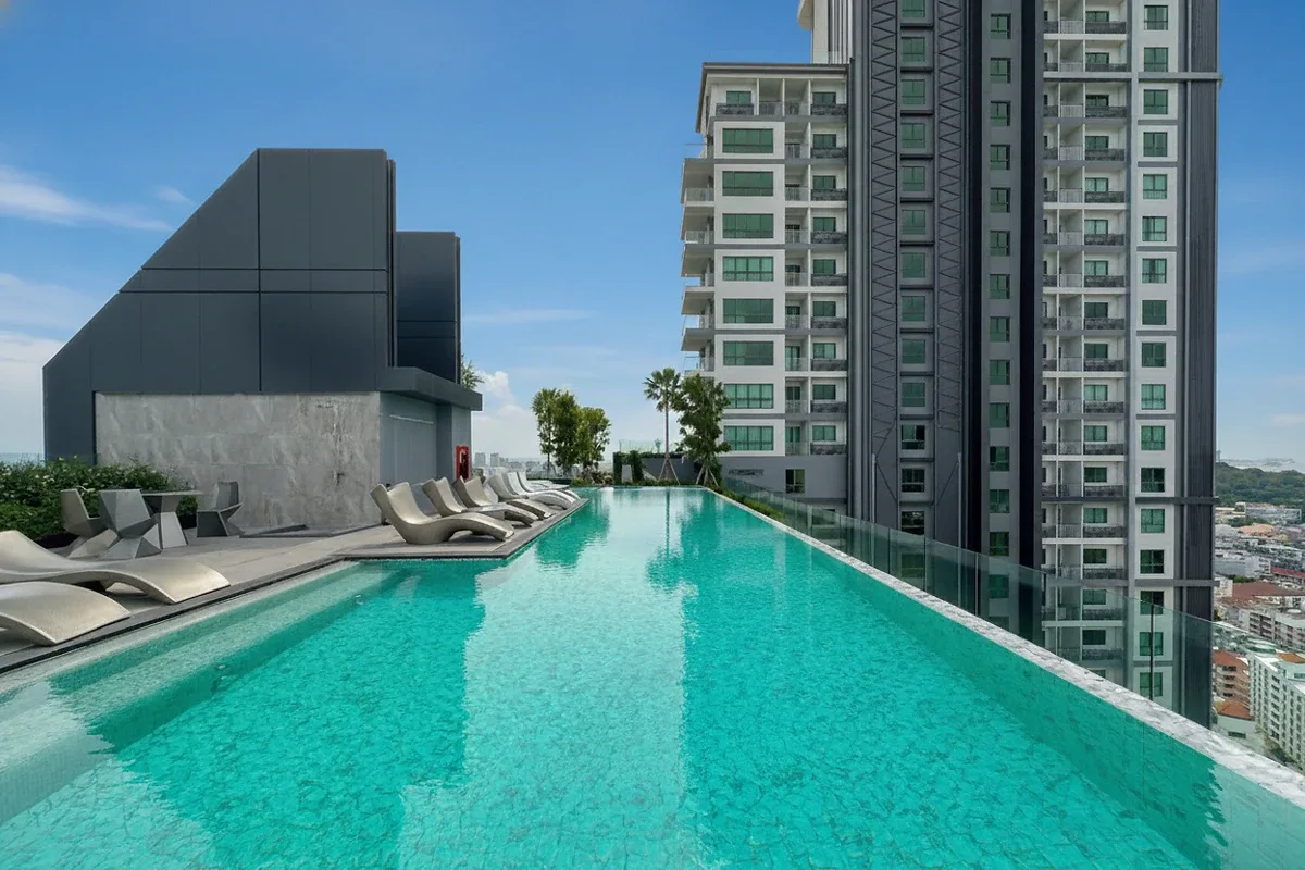 Arcadia Millennium Tower rooftop infinity pool with lounge chairs, overlooking the city and adjacent buildings.