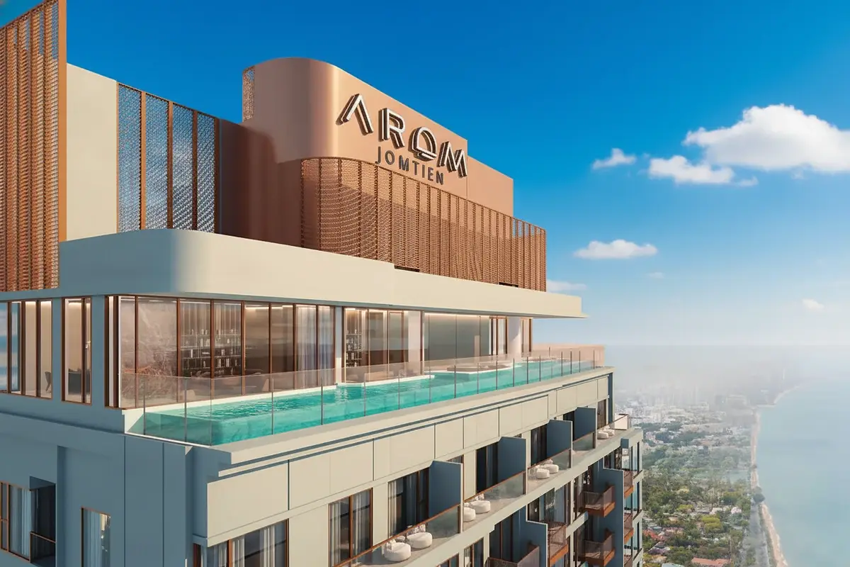 Arom Jomtien high-rise building exterior with rooftop pool and ocean view under a cloudy sky.