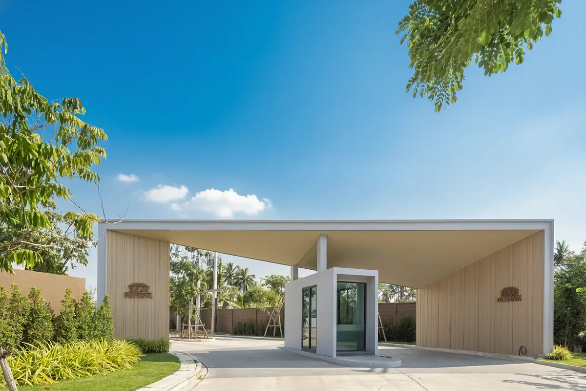 Baan Pattaya 6 modern entrance gate with security booth and lush landscaping under a bright sky.