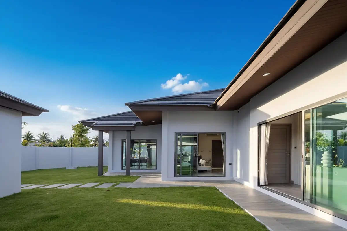 Baan Pattaya 6 modern clubhouse with a gym, illuminated at dusk, next to a swimming pool.
