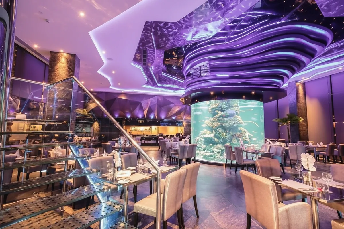 Centara Avenue Residence and Suites modern fitness center with cardio machines and weights, visible through a large glass window.