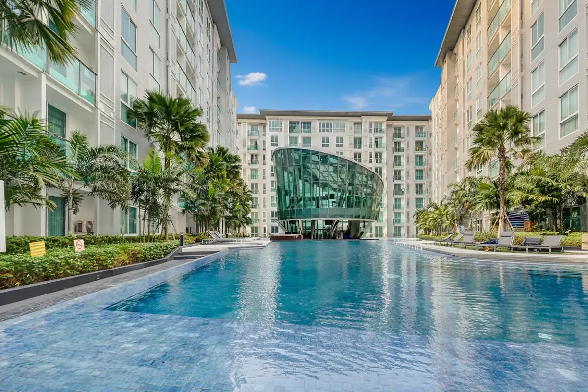 City Center Residence large swimming pool surrounded by modern buildings and lounge chairs.