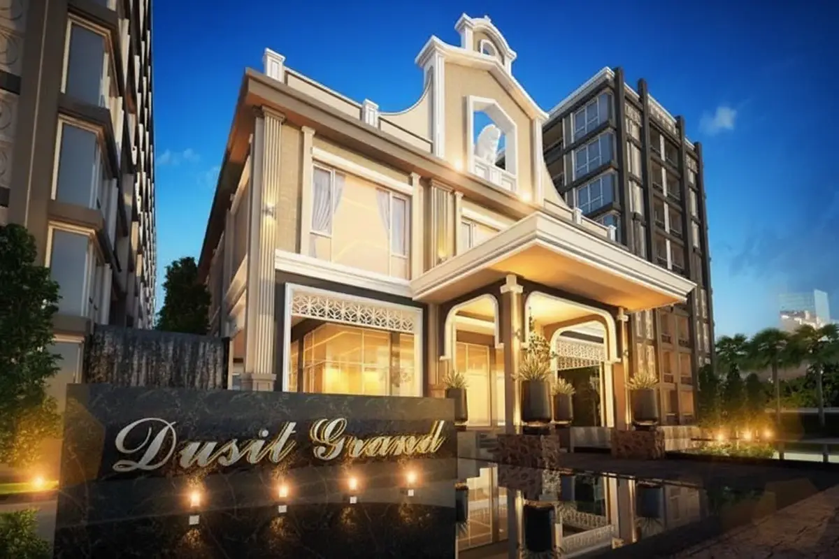 Dusit Grand Park 2 main building entrance at night, with illuminated Dusit Grand sign and water feature.