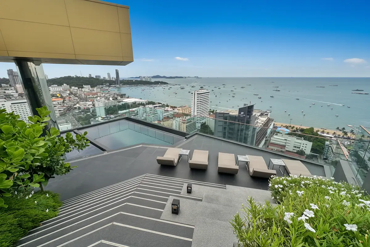 EDGE Central Pattaya: Tall, modern high-rise building with glass and dark gray facade against a bright sky.