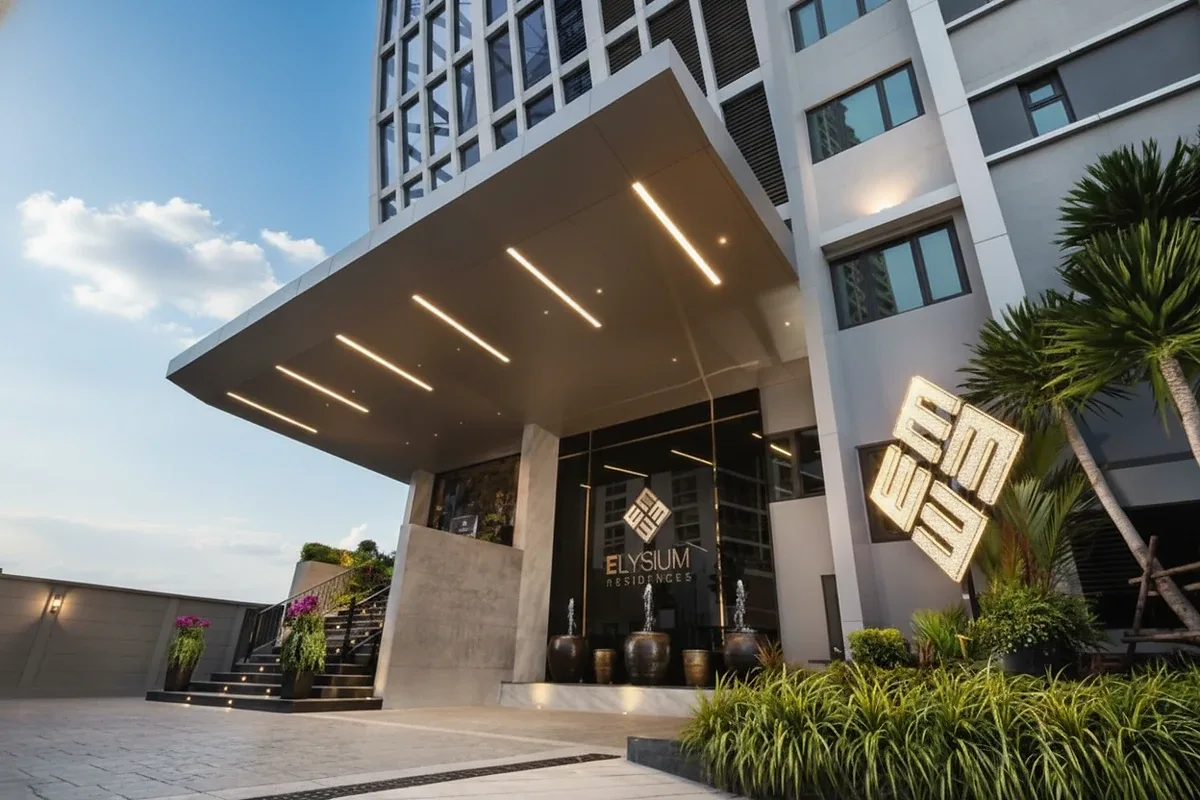 Elysium Residences modern building entrance at dusk with illuminated canopy and logo.