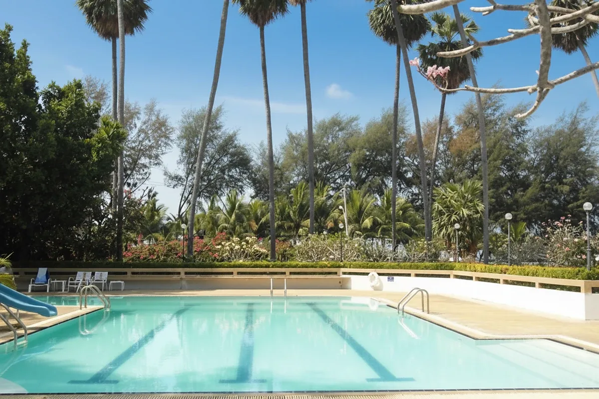 Grand Condotel outdoor swimming pool with blue slide, lounge chairs, and condo building in background.