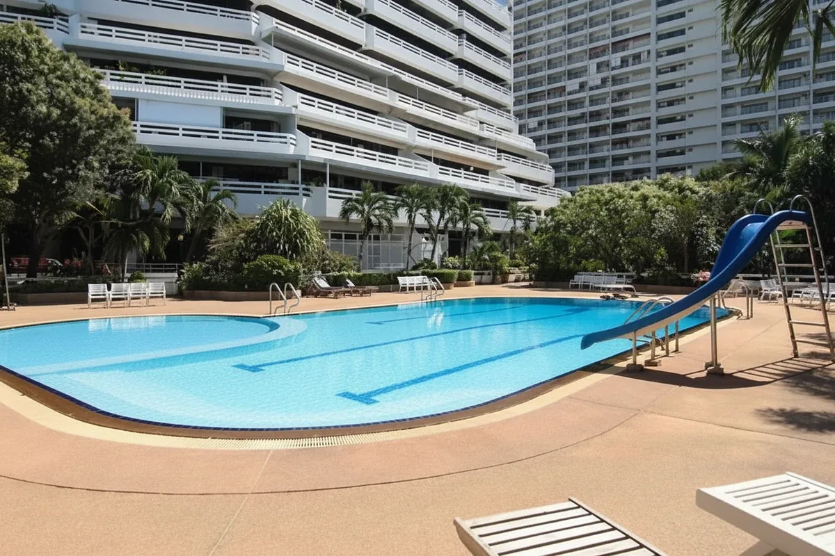 Grand Condotel outdoor swimming pool surrounded by tall palm trees and tropical greenery.