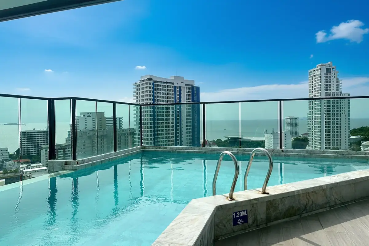 Jewel Pratumnak modern high-rise building exterior with balconies and palm trees.
