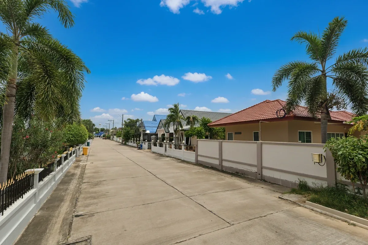 Natheekarn Park View residential street view with traditional houses, palm trees, and overhead power lines.