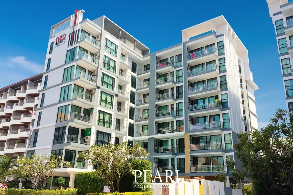 Neo Condo exterior view of modern building with balconies and large windows under a clear blue sky.