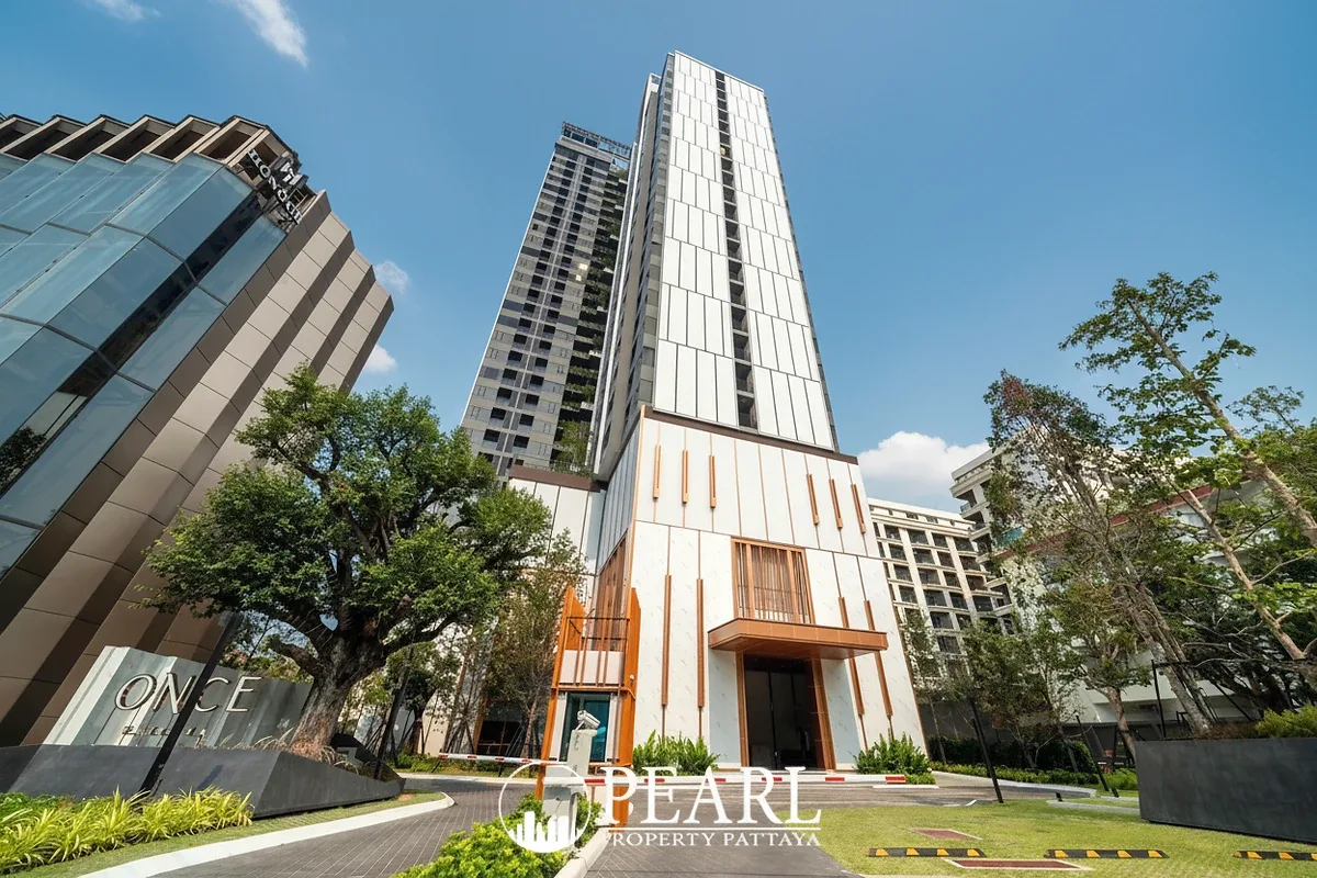 Once Pattaya modern condo building exterior with contemporary architecture and lush green landscaping.