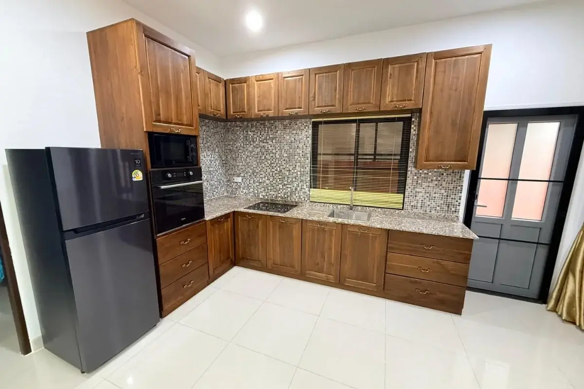 3 Bedroom House for Sale at Baan Dusit Pattaya Park kitchen with wooden cabinets, built-in appliances, and tiled backsplash.