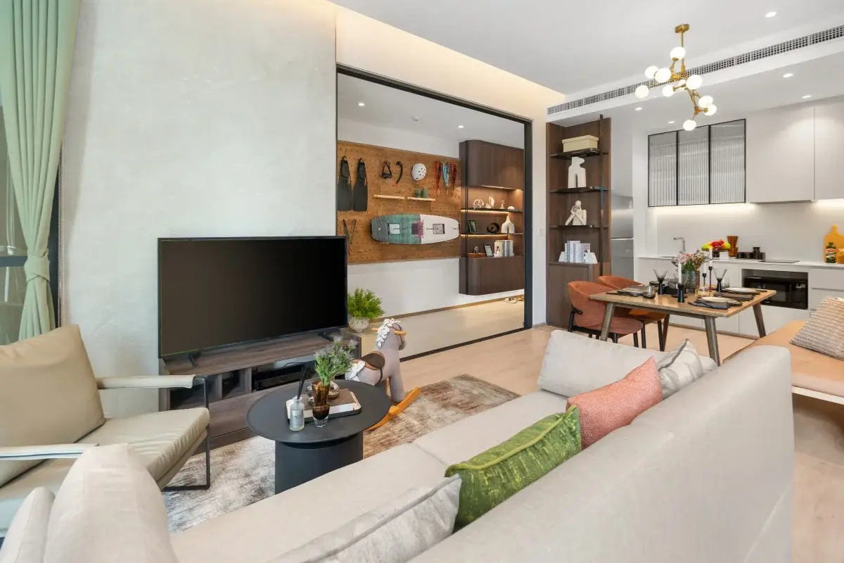 1 Bedroom Condo for Sale at Once Wong Amat: living room with large sofa, TV, and dining area visible through sliding doors.