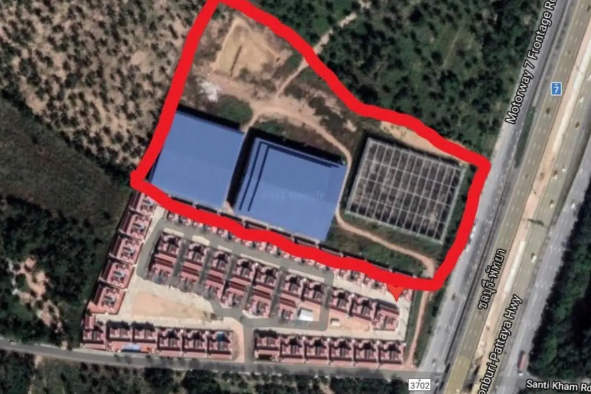 Land for Sale in Nong Pla Lai, aerial view of the property outlined in red, showing buildings, highway, and residential area.
