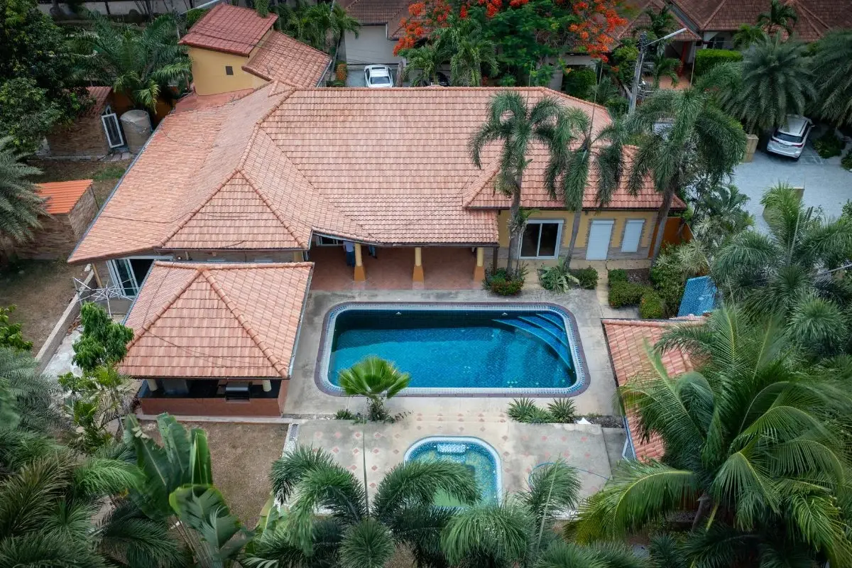 5 Bedroom House for Sale in Huai Yai from an aerial view, showcasing the house, two pools, and surrounding greenery.