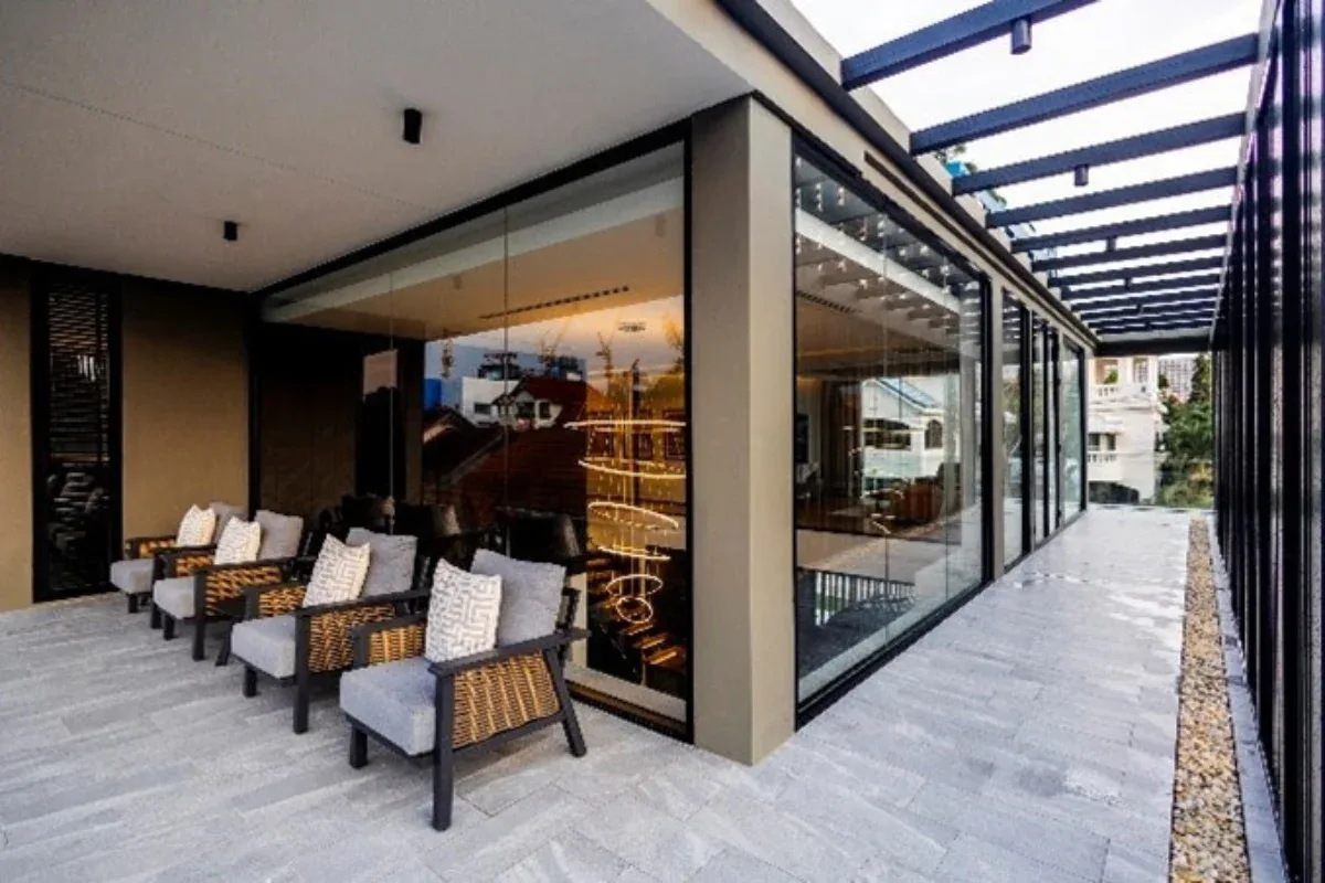 5 Bedroom House for Rent at Casa Jomtien: Outdoor covered terrace with lounge chairs and glass walls.