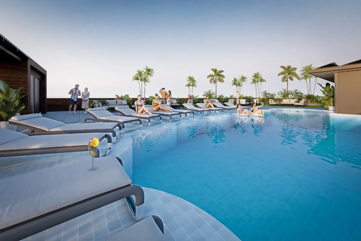 Siam Oriental Beach rooftop pool with sun loungers, palm trees, and people relaxing under a bright sky.