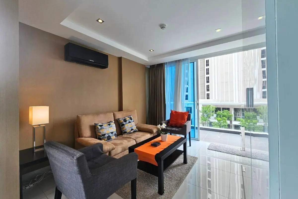 1 Bedroom Condo for Sale & Rent at Serenity Wongamat with living room sofa, armchair, and balcony view.