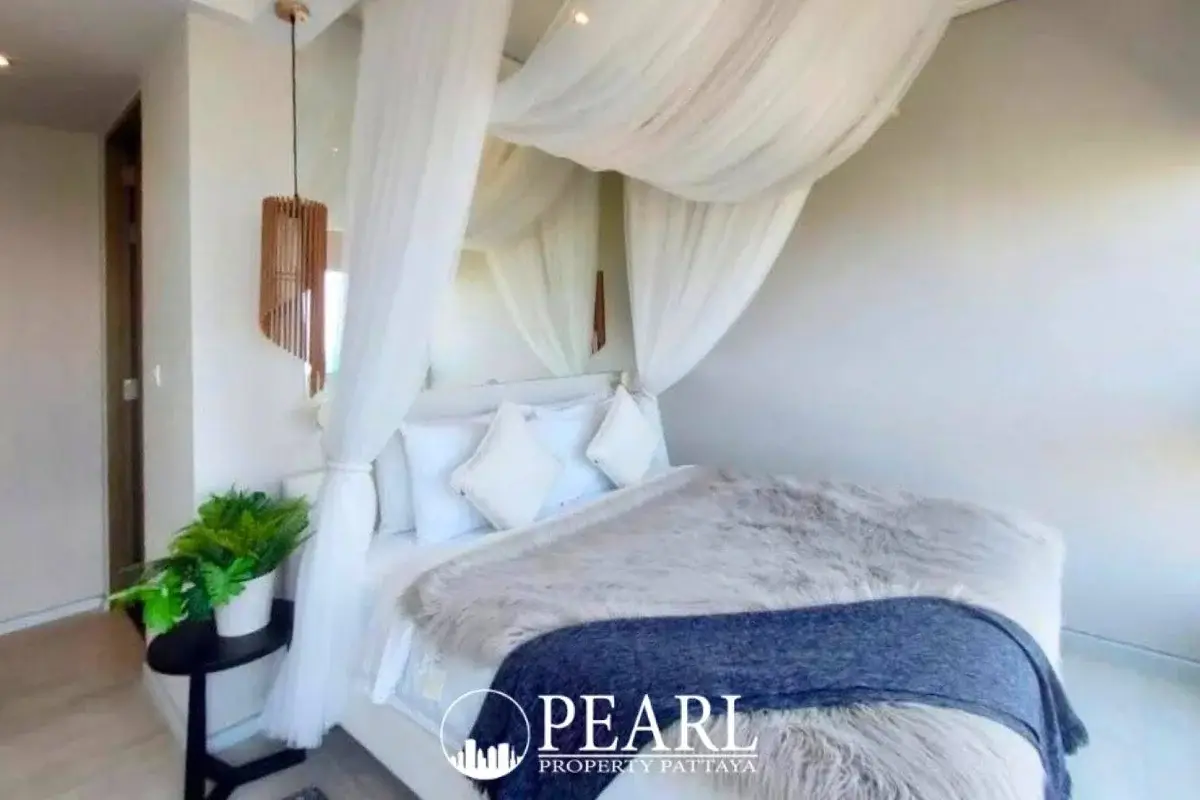 2 Bedroom Condo for Sale at Veranda Residence Pattaya bedroom with white canopy bed and decorative plant.
