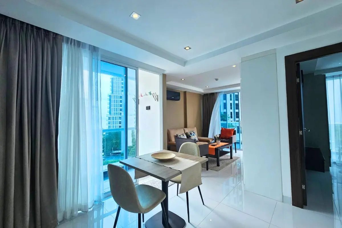 1 Bedroom Condo for Sale & Rent at Serenity Wongamat with dining table, living room, and balcony view.