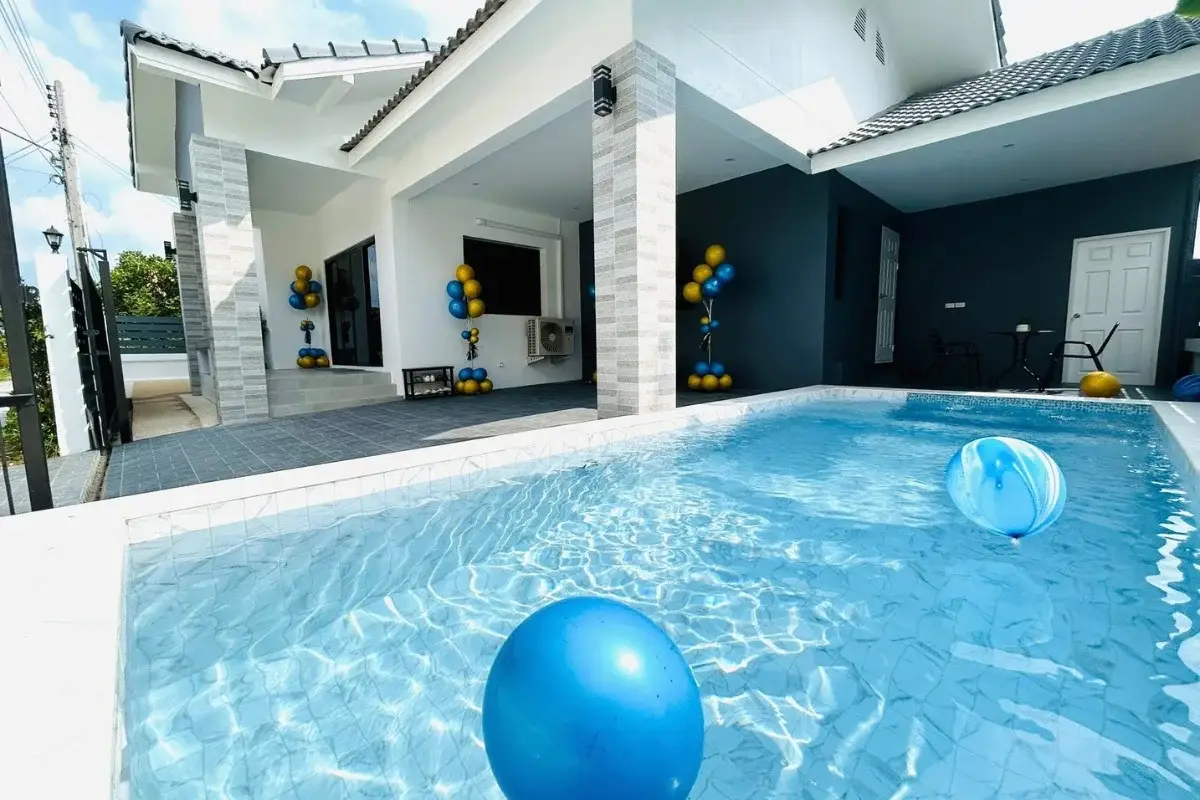 3 Bedroom House for Sale in Nong Prue outdoor swimming pool with blue balloons and house exterior in background.