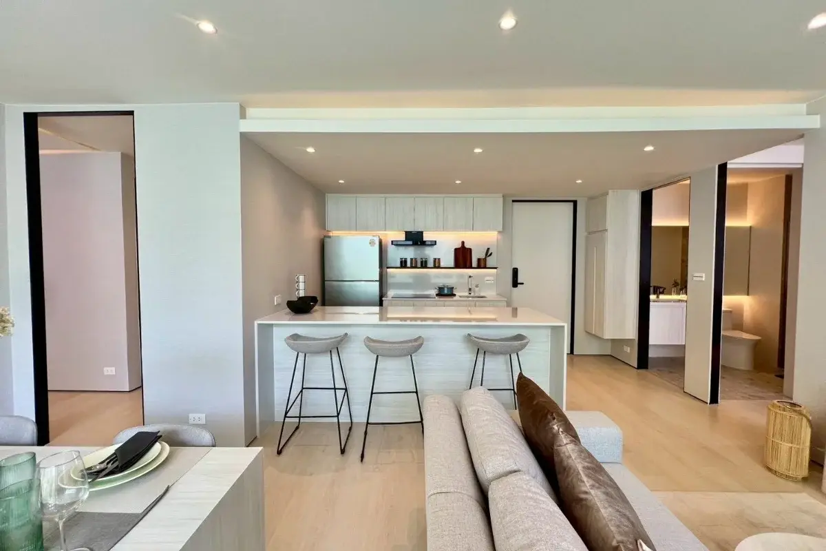 2 Bedroom Condo for Sale at Celine Wongamat open-plan kitchen island with bar stools and living area in background.