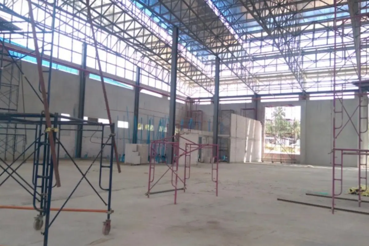 Land for Sale in Nong Pla Lai, interior of a large warehouse-like structure under construction with scaffolding.
