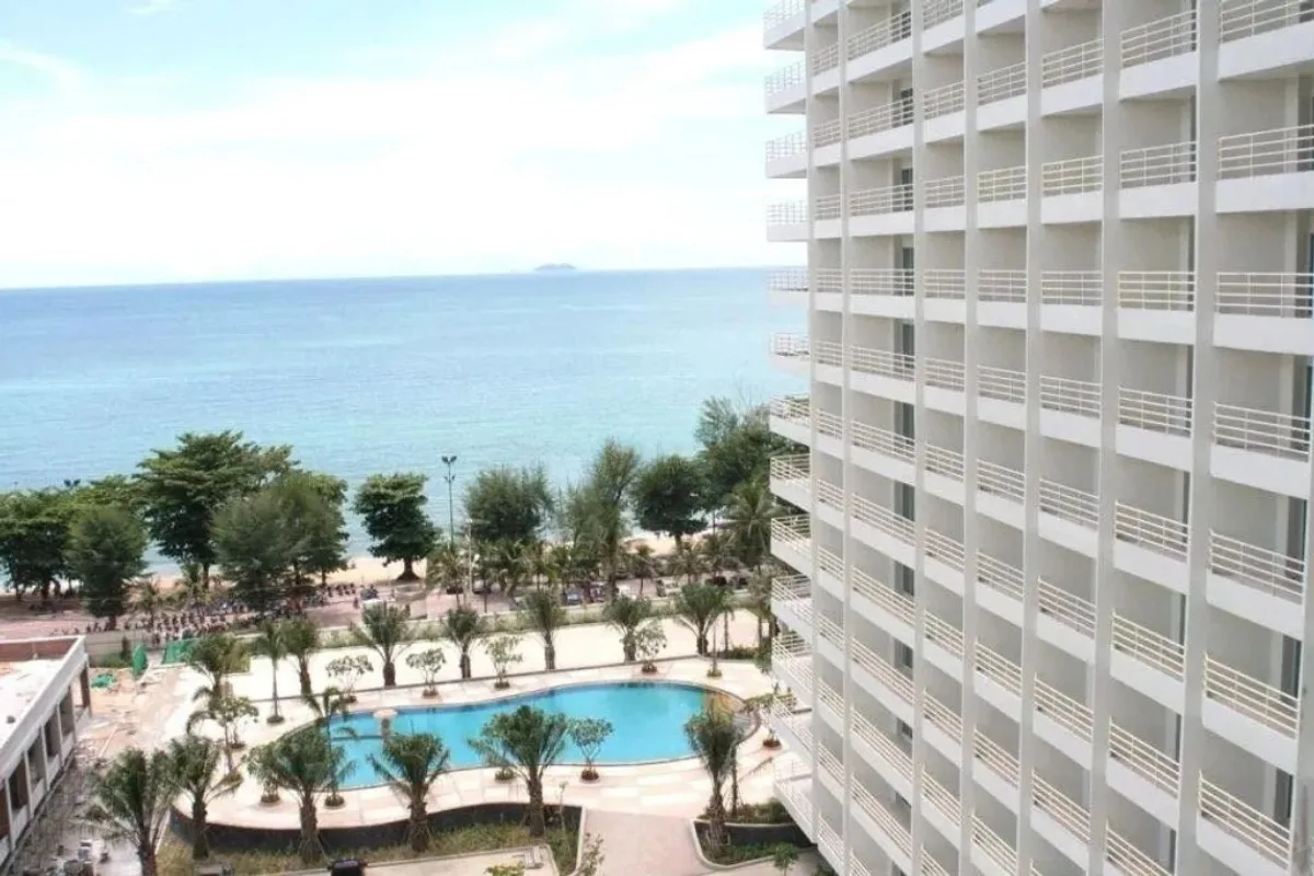 View Talay 7 aerial view of the condo complex, large pool, and beach with ocean beyond.