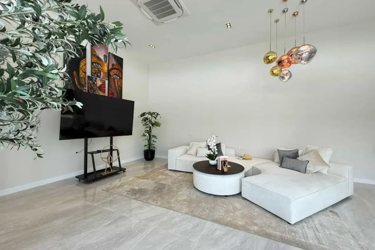 3 Bedroom House for Sale & Rent at The Prospect: Living room with white sectional sofa, coffee table, TV, and colorful pendant lights.