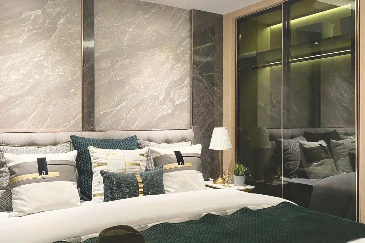 Studio Condo for Sale at Pristine Park 3 bedroom with patterned wall, bed, pillows, and mirrored wardrobe.