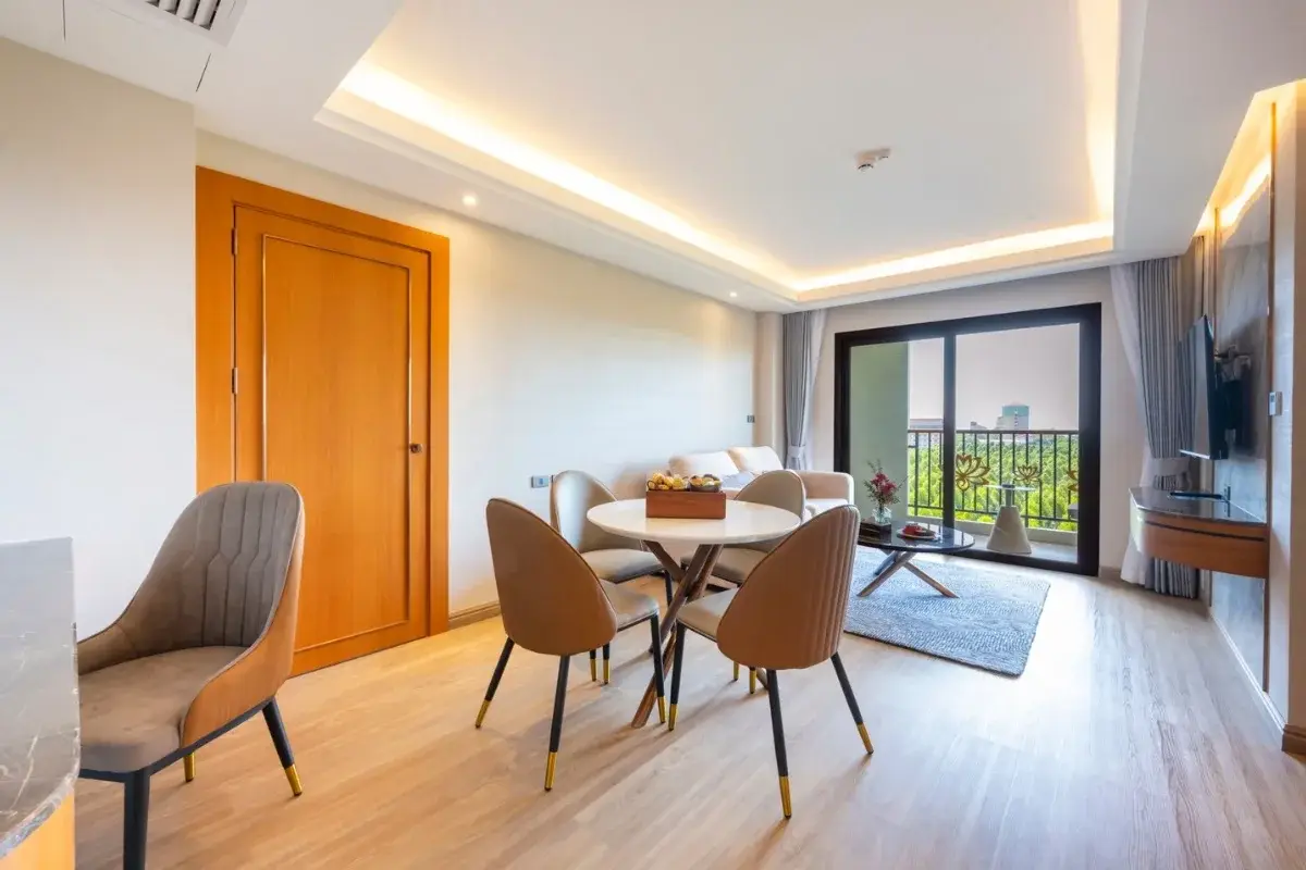 2 Bedroom Condo for Sale at Wyndham Jomtien Pattaya - living space with dining table and balcony overlooking city.