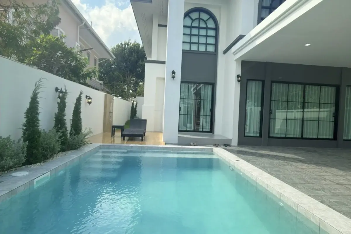 5 Bedroom House for Sale at Baan Suan Lalana, private swimming pool next to the house with a lounge chair.