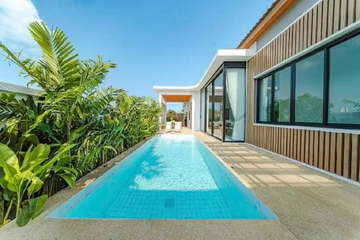 4 Bedroom House for Sale in Bang Lamung featuring a long, narrow swimming pool alongside the modern house exterior.