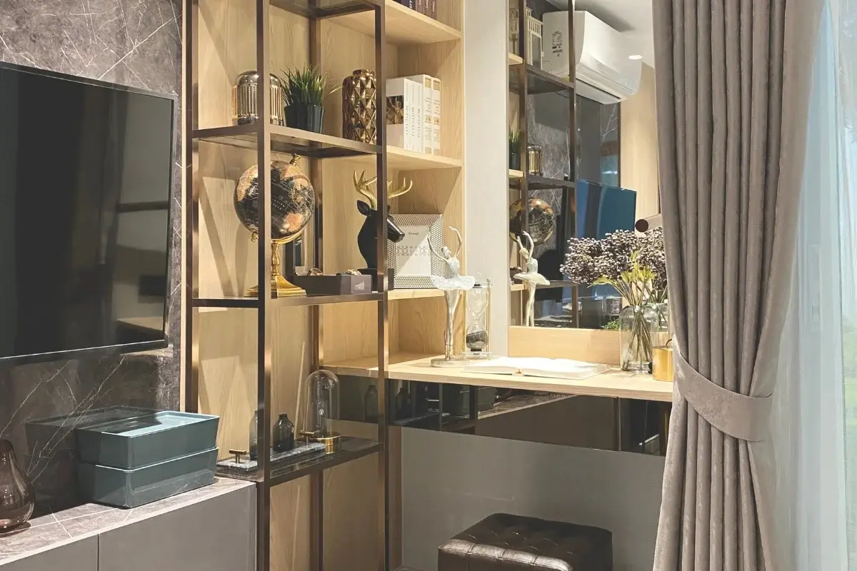 Studio Condo for Sale at Pristine Park 3 living area with TV, decorative wooden shelves, and a desk.