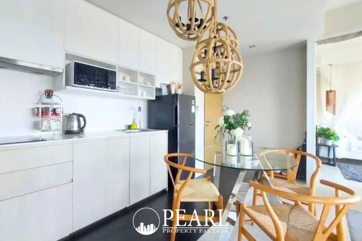 2 Bedroom Condo for Sale at Veranda Residence Pattaya kitchen with white cabinets, microwave, and dining area.