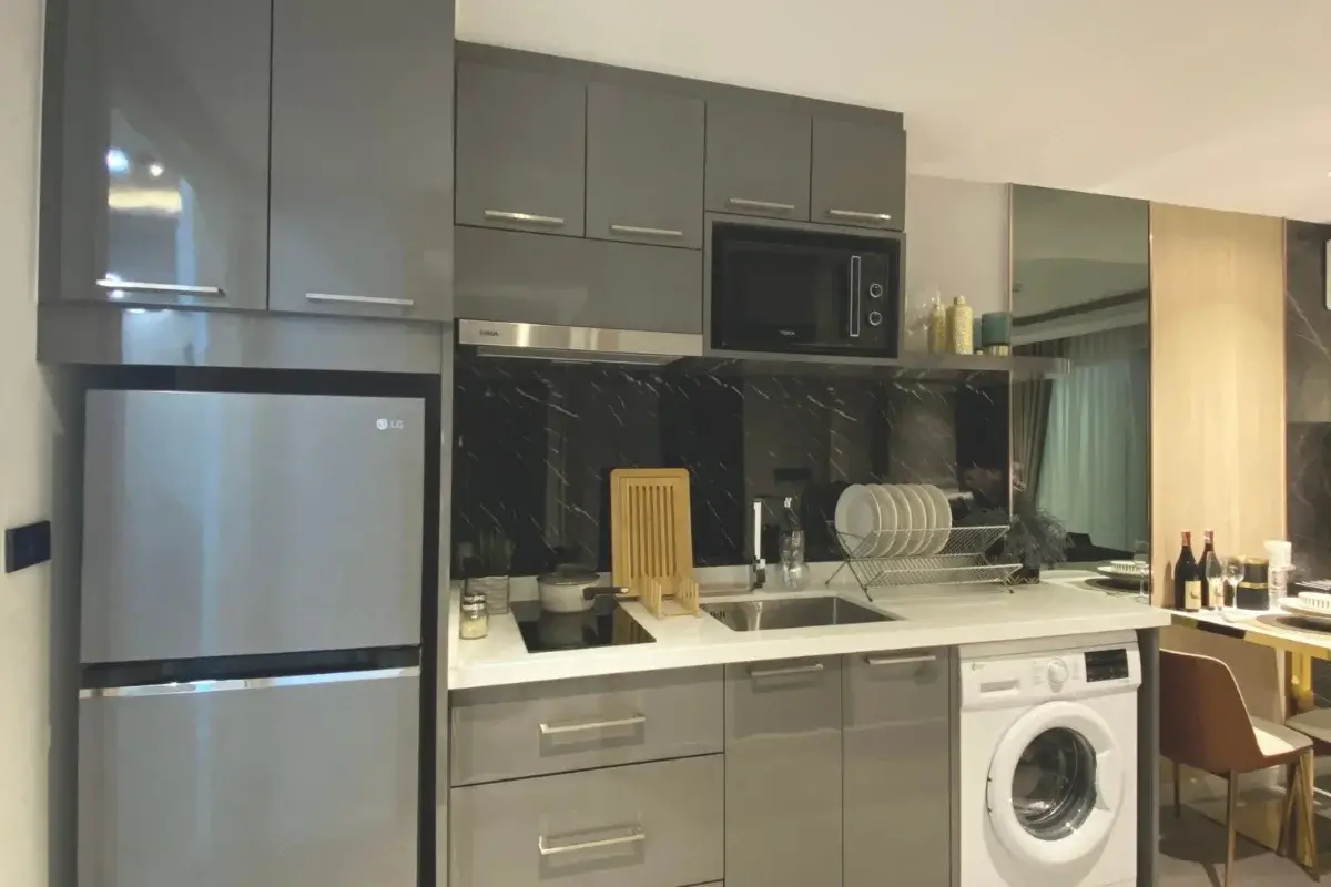 Studio Condo for Sale at Pristine Park 3 kitchenette with gray cabinets, refrigerator, sink, and washing machine.