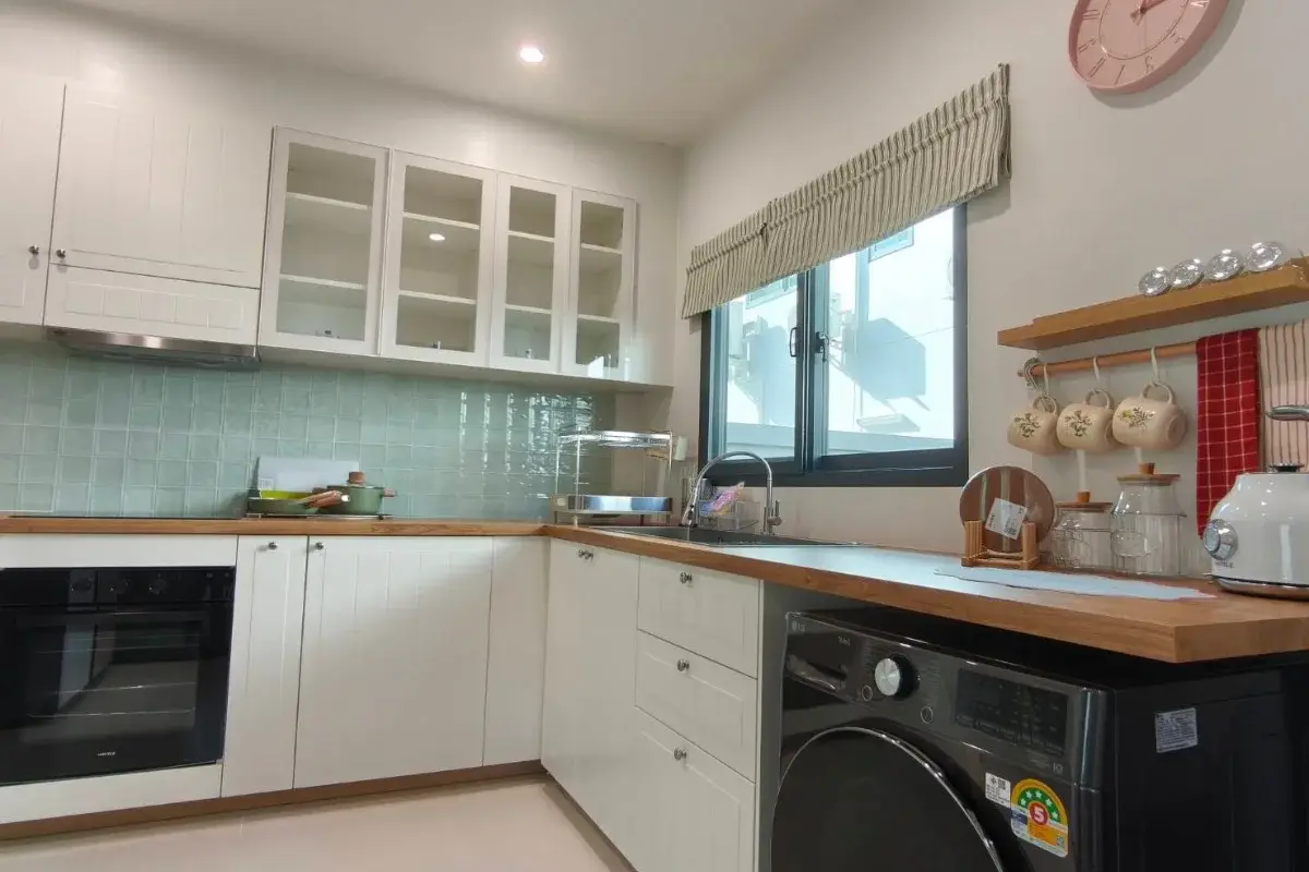 4 Bedroom House for Rent at Supalai Palm Ville Sukhumvit - Rongpo - kitchen with white cabinets, wood countertops, and a washing machine.