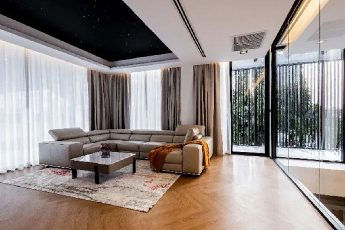 5 Bedroom House for Rent at Casa Jomtien: Bright living room with L-shaped sofa, coffee table, and large windows.