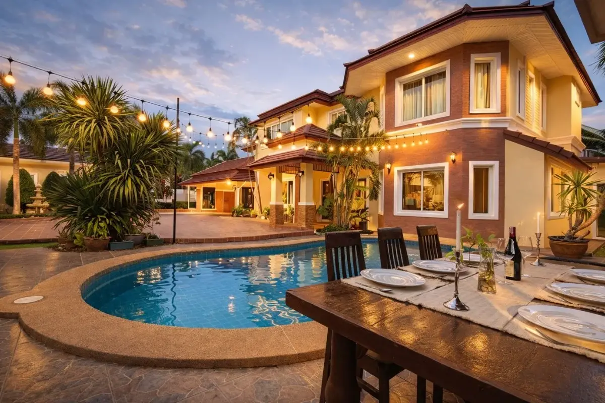 5 Bedroom House for Sale in Nong Prue, exterior at dusk with pool, string lights, and outdoor dining table.