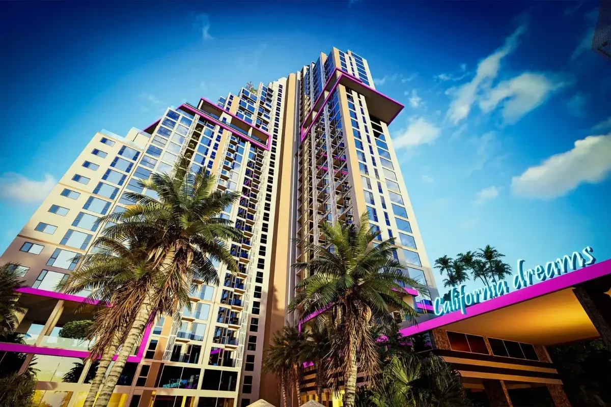 The Riviera Santa Monica tall building exterior from a low angle, showing palm trees and a bright blue sky.