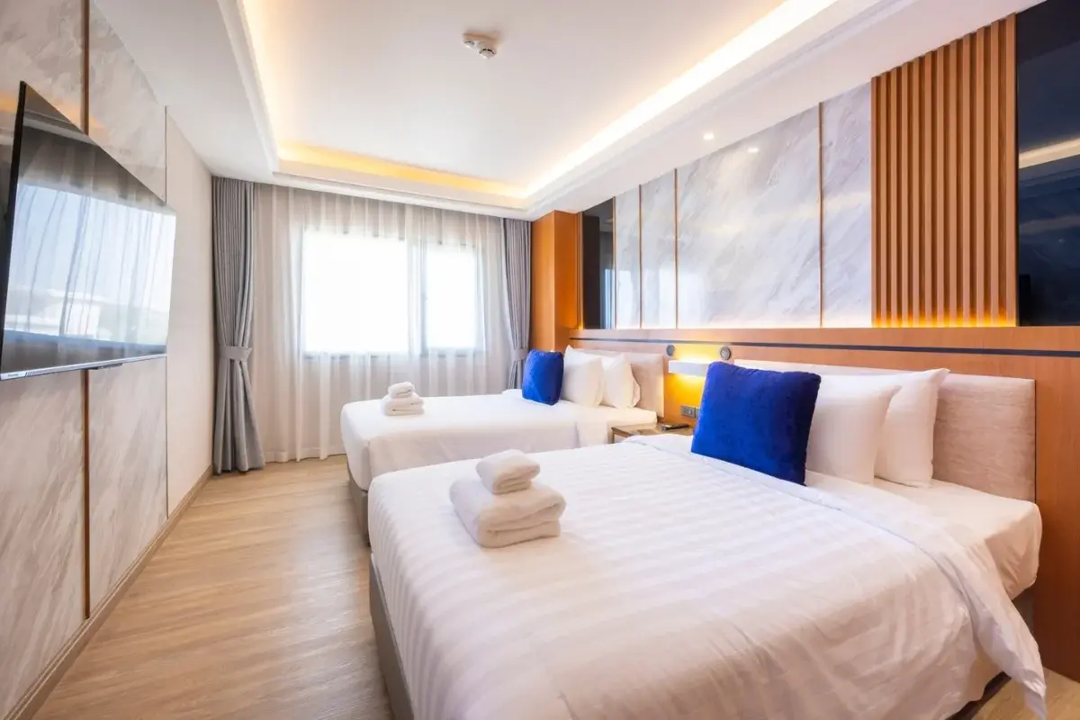 2 Bedroom Condo for Sale at Wyndham Jomtien Pattaya - bedroom with two beds, blue pillows, and large window.