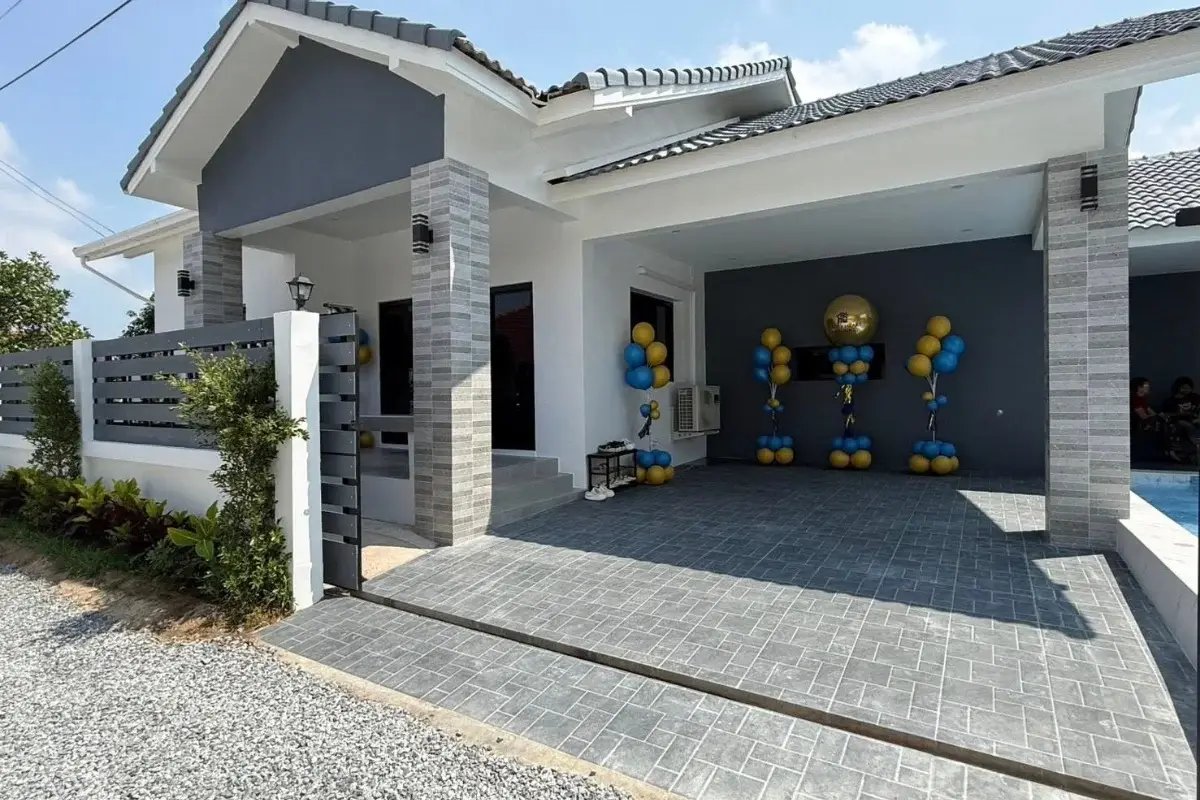 3 Bedroom House for Sale in Nong Prue front exterior with paved driveway, covered parking, and festive balloons.