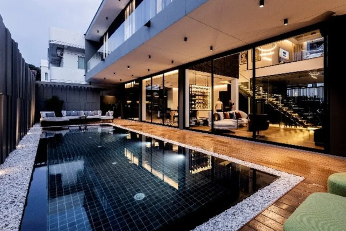 5 Bedroom House for Rent at Casa Jomtien: Outdoor swimming pool with wooden deck and view into the living area.